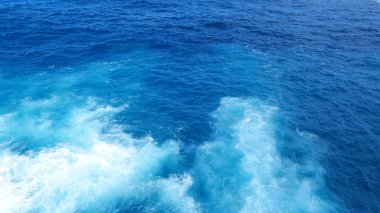 Mavi deniz deniz okyanusu, bulanık arka planda tropikal dev bir dalga. Açık havada deniz mavisi okyanus beyaz dalgası hareketi. Aqua marine dev dalga deniz yaz arkaplanı. Turkuaz cennet su manzarası