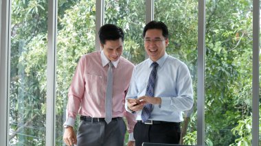 Excited two businessman ceo company achievement. Success Businessman happy got good news mobile smartphone. Asian young businessman raises hand happy, smiling, excited got great news from phone lucky