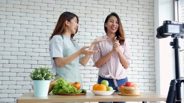 İki Asyalı vlogcu birlikte sağlıklı bir yaşam tarzı gözden geçiriyorlar. İki Genç Kadın Arkadaş blogcusu Mutlu Yaşam Biçimi Canlı Yayın. İki kadın sosyal medyadan konuşuyor, merhaba de.
