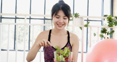 Sağlıklı bir kadın organik salata kasesini sağlıklı bir yaşam tarzında tutuyor. Sağlıklı Asyalı kadınlar organik yeşil salata sebze yemeği giyiyorlar. Güzel kız sağlık hizmetleri vegan sağlık yaşam tarzı konsepti