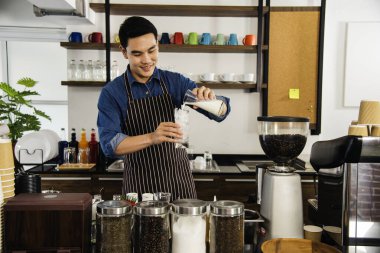 Kahve yapan adam kahve makinesinden espresso shot yapıyor. İtalyan kafeteryasında sütlü kapuçino. Kahve makinesinin ellerini kapat. Müşteri kafeteryası için kahverengi latte yap.