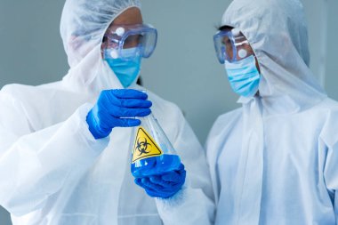 İki Asyalı bilim adamı kimya bilimi tüpü deney tüpü antikor örneğini kovid-19 virüsüne karşı laboratuvar geliştirmek için depoluyorlar. Kimya Laboratuarı 'nda bilim adamı danışmanı, analizi