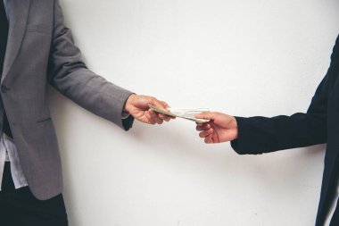 El sıkışın ve rüşvet verin. El ele tutuşan dolar banknotları rüşvet para ekonomisi iş adamları. İş adamları yasadışı yerleşim yerlerini yozlaştırıp rüşvet ödemeye çalışıyorlar. Rüşvet konsepti