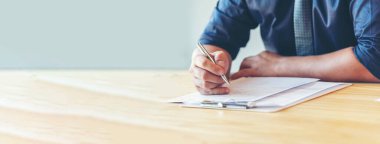 Finansal grafik grafiklerini okuyan Banner İşadamı bilgi verileri planlıyor. Banner Men 'in elleri ofis masasındaki grafik çizelgesine bakıyor. Fotokopi alanı ile Asyalı erkek ofis iş bilgileri