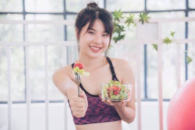 Sağlıklı bir kadın organik salata kasesini sağlıklı bir yaşam tarzında tutuyor. Sağlıklı Asyalı kadınlar organik yeşil salata sebze yemeği giyiyorlar. Güzel kız sağlık hizmetleri vegan sağlık yaşam tarzı konsepti