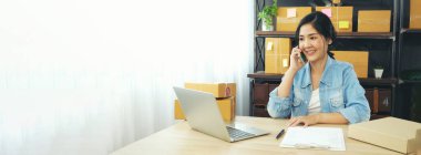 Banner Çevrimiçi satıcı elleri kapatın dizüstü bilgisayarda klavye yazan Asyalı genç kadın hisse senedi teslimat paketinin siparişini kontrol ediyor. Asyalı kadın ev ofisinde fotokopi alanı olan küçük bir iş kurdu