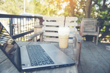 Ofis dizüstü bilgisayarının finansal döküman şeması ve kahve fincanı ile ahşap masanın üzerindeki grafiği. Düz dizüstü bilgisayar ofis masasında duruyordu. İş sahasında iş grafiği modellemesi yok