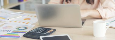 Ev ofis masasında dizüstü bilgisayar kullanan Asyalı kadın serbest yazar. Finansal grafik çizelgesi okuyan kadın pazarlama verilerini analiz ediyor. Ofiste çalışan Asyalı kadınlar, iş konuları, kahve fincanları.