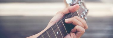 Yeşil parkta akustik gitar çalan yakışıklı adamlar. Genç adam evde akustik gitar enstrümanı çalıyor, genç Asyalı müzisyen yaşam tarzı güzel. Mutlu gitarist