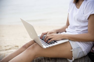 Ev işlerinde bilgisayarlı dizüstü bilgisayar kullanan bir kadın evde çalışıyor. Dizüstü bilgisayar kullanan Asyalı iş kadını. Klavye dizüstü bilgisayarı yazan mutlu programcı kadın çevrimiçi web sitesi okuyor