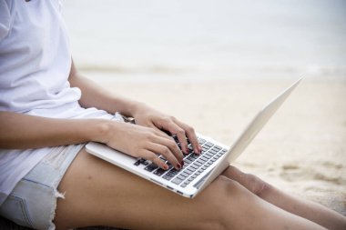 Ev işlerinde bilgisayarlı dizüstü bilgisayar kullanan bir kadın evde çalışıyor. Dizüstü bilgisayar kullanan Asyalı iş kadını. Klavye dizüstü bilgisayarı yazan mutlu programcı kadın çevrimiçi web sitesi okuyor