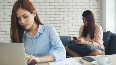 Finansal grafik grafiklerini okuyan iki Asyalı kadın pazarlama verilerini analiz etmeyi planlıyor. Asyalı takım çalışanı ofis firması. Şirket masasında dizüstü bilgisayarla iki iş kadını buluşması..