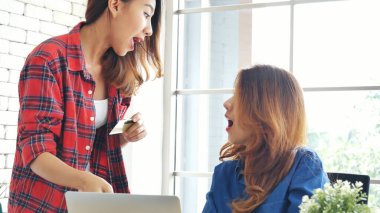 İki arkadaş internetten alışveriş yapıyor. İnternet sitesinde bilgisayardan alışveriş yapıyor. Gülümseyen yüzlü, mutlu. İnternetten bilgisayar alışverişi yapan mutlu Asyalı kadınlar, yeni konsept ödeme