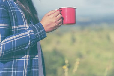 Green Garden Cafe 'de elinde siyah kahve fincanı olan bir kadın. İş kadınlarının elleri sıcak kahve içmeye bayılır. Kahveli iş kadınları ya da kahve dükkanında sıcak çikolata. Kafein içmek