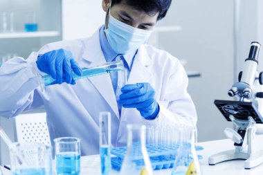 Kimyasal test tüpü tutan bir bilim adamı bilim laboratuvarını test ediyor. Doktor Klinik Sağlık Laboratuvarı Teknisyen Teşhisi. Aşı testinde çalışan Asyalı bilim adamı tıbbi biyokimya laboratuvarı