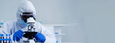 Banner Scientist bilim laboratuarında mikroskop araştırmasına bakıyor. Banner Asyalı bilim adamı laboratuvar ekipmanları kimya laboratuvarında mikrobiyoloji mikroskobu kullanıyor. Kopya alanı ile biyokimya deneyi