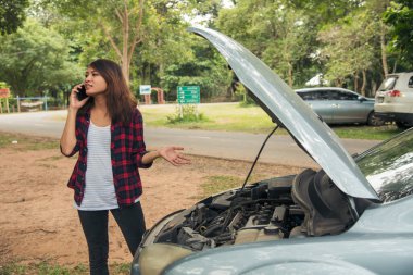 Asyalı kadınlar araba arızası için sigorta acentesini kullanıyorlar. Kadın tamirci teknisyenini arıyor. Tamir onarım desteği. Taşıma aracı kazası acil durum sorunu