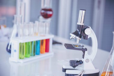 Biyoloji kimya laboratuvarında mikroskop ekipmanı. Laboratuvar masa mikrobiyolojisi ekipmanları üzerinde bilimsel deney mikroskobu. Laboratuvar arka planında kimya nesneleri. Kimya bilimsel kavramı
