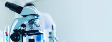 Biyoloji kimya laboratuvarında Banner Science mikroskop ekipmanı. Laboratuvar masa mikrobiyolojisi ekipmanları üzerinde bilimsel deney mikroskobu. Laboratuvar arka planında kopyalama alanı olan Sancak Kimyası nesneleri