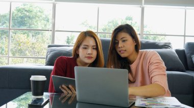 İki iş ortağı akıllı telefondan gelen iyi haberlerin tadını çıkarıyor. Takım çalışması takım çalışması konsepti. Asyalı kadın iş adamları ev ofisinde birlikte çalışıyorlar. Başarı kendine güvenen kadın takım çalışması