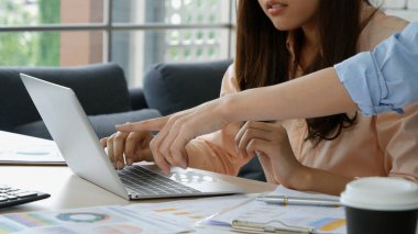 Finansal grafik grafiklerini okuyan iki Asyalı kadın pazarlama verilerini analiz etmeyi planlıyor. Asyalı takım çalışanı ofis firması. Şirket masasında dizüstü bilgisayarla iki iş kadını buluşması..