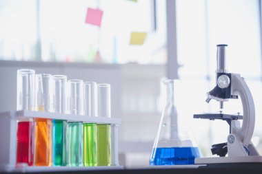 Mikroskop, cam tüpler, kimyasal deney şişesi beyaz masa bilimsel arka planı olan bilim laboratuarı kimya laboratuvarı. Renkli Sıvı Biyoloji Laboratuvarı Kimyasal Sıvı Bilimi Deneyi
