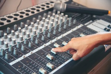 Üretim ses mühendisi kadın elleri ses dengeleyici sesi ayarlıyor, konsolu karıştırıyor. DJ ses mühendisliği stüdyonun ses kontrolü üzerinde çalışıyor. Yapımcı remix müzik ses kaydı