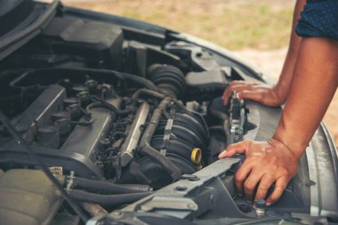 Tamirci ellerini kapayıp araba tamirhanesini tamir ediyor. Lastik değiştiriyor. Adam elleri şok emici makine araç mekanik servisini tamir ediyor. Araç bakım mühendisi.