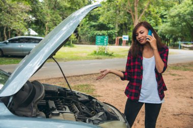 Asyalı kadınlar araba arızası için sigorta acentesini kullanıyorlar. Kadın tamirci teknisyenini arıyor. Tamir onarım desteği. Taşıma aracı kazası acil durum sorunu