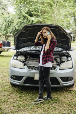 Asyalı kadınlar araba arızası için sigorta acentesini kullanıyorlar. Kadın tamirci teknisyenini arıyor. Tamir onarım desteği. Taşıma aracı kazası acil durum sorunu