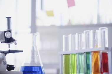 Mikroskop, cam tüpler, kimyasal deney şişesi beyaz masa bilimsel arka planı olan bilim laboratuarı kimya laboratuvarı. Renkli Sıvı Biyoloji Laboratuvarı Kimyasal Sıvı Bilimi Deneyi