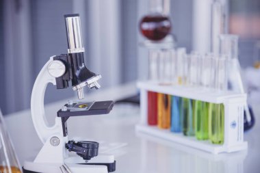 Mikroskop, cam tüpler, kimyasal deney şişesi beyaz masa bilimsel arka planı olan bilim laboratuarı kimya laboratuvarı. Renkli Sıvı Biyoloji Laboratuvarı Kimyasal Sıvı Bilimi Deneyi