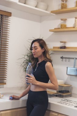 Modern şehirde su şişesi içen kadınlar spor kıyafetlerini dışarıda giyerler. Dışarıda güneşli bir havada egzersiz yapan genç bir kadın. Sağlıklı sağlık yaşam tarzı kadın konsepti