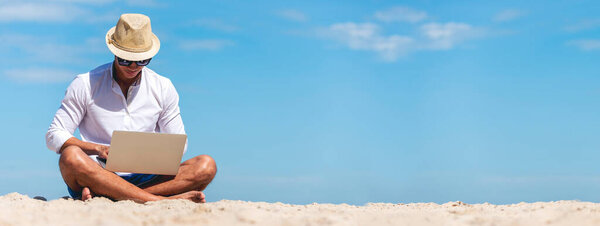 Баннер Человек путешественник использовать ноутбук на летнем пляже голубое небо. Азиатский человек путешествует расслабиться сидя летний пляжный остров. Человек печатает ноутбук компьютер праздник деловой поездки фрилансер, работающий в Интернете с копировальным пространством