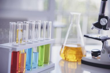 Mikroskop, cam tüpler, kimyasal deney şişesi beyaz masa bilimsel arka planı olan bilim laboratuarı kimya laboratuvarı. Renkli Sıvı Biyoloji Laboratuvarı Kimyasal Sıvı Bilimi Deneyi