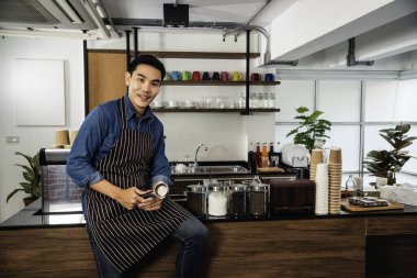 Portre Barista küçük işletme sahibi. Asyalı kahveci adam gülümsüyor. Kameraya bakın. Küçük işletme özgüvenli kişi.