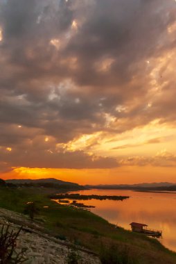 Günbatımında tropikal inanılmaz dramatik altın gökyüzü manzaralı nehir kıyısı okyanusu üzerinde. Siluet sükunet mevsimi vahşi doğa huzur manzarası. Sakin göl kırsalında güneş doğarken deniz kıyısında yansıma