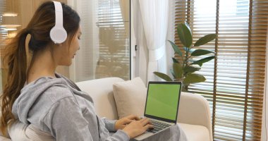 Boş Yeşil Ekran dizüstü bilgisayar blogcusu kadının elleri dizüstü bilgisayarda klavye kullanıyor. Dizüstü bilgisayarlı kanepe oturma odasını kullanarak kadın ellerini kapat. Serbest çalışan kadınlar ev içi video konferansında çalışıyorlar.