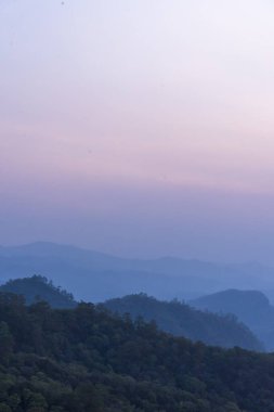 Dikey Güzel Dağ manzarası sisli rüzgarlı dağ sıraları yeşil Asya manzarası çiftliği. Dikey İnanılmaz Peyzaj Dağları yeşil çayır beyaz bulut mavi gökyüzü gün doğumu. Kırsal manzara
