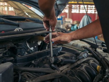 Otomobil makinelerinin mekanik servisini tamir eden elleri kapatın. Tamirci araba tamirhanesini tamir ederken ellerini kaldırdı. Araç kaputu otomobili kontrol ediyor. Araç bakım mühendisi.