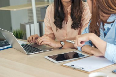 İki iş kadını takım toplantısı şirket masasında dizüstü bilgisayarla yapılıyor. Finansal grafik grafikleri okuyan iki genç kadın pazarlama verilerini analiz etmeyi planlıyor. Asyalı ekip çalışma bürosu.