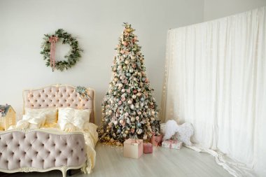 Yatak odasında süslü Noel ağacı var.