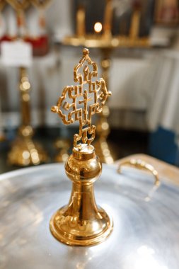 Bir bebek için vaftiz fontunun kapağında altın kilise haçı