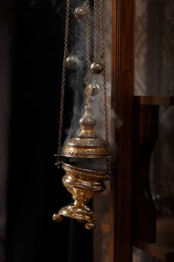 Kilise tütsüsü altın bir merkezden yükselir.