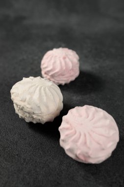 Yumuşak ve pofuduk beyaz ve pembe marşmelovlar çarpıcı bir siyah arkaplan karşısında güzel bir tezat oluşturuyor. Şekerleme reklamları, tatlı temalı tasarımlar ya da projenize biraz kapris katmak için mükemmel bir görsel kompozisyon.