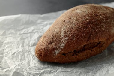 Bu büyüleyici görüntü, parşömen kağıdının üzerinde duran ev yapımı kuru üzümlü ekmeği gösteriyor. Mutfak yayınları, yemek blogları ya da pastane promosyonları için mükemmel. Sıcak ve konforlu bir ortam yayıyor. Seyircileri basit bir zevkten zevk almaya davet ediyor.