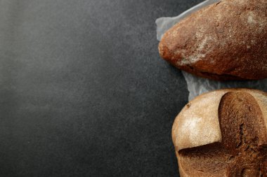 Bu büyüleyici görüntü, parşömen kağıdının üzerinde duran ev yapımı kuru üzümlü ekmeği gösteriyor. Mutfak yayınları, yemek blogları ya da pastane promosyonları için mükemmel. Sıcak ve konforlu bir ortam yayıyor. Seyircileri basit bir zevkten zevk almaya davet ediyor.