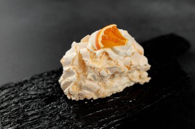 Kremalı pasta. Krem şantili protein ve şeker, krem peyniri siyah bir kesim tahtasındaki krem ve peynire dayandırır.