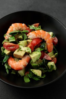 Kral karides salatası, avokado, salatalık, domates ve otlar. Siyah arkaplan