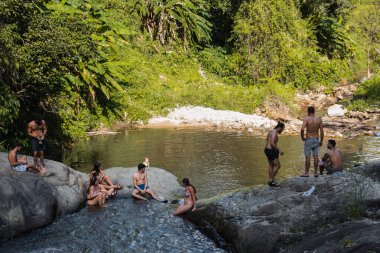 Mo Paeng Waterfall in Pai, Thailand with tourists spending time and swimming in the pool.